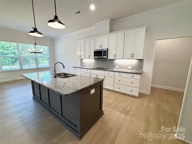 a kitchen with stainless steel appliances granite countertop a sink a stove and a refrigerator