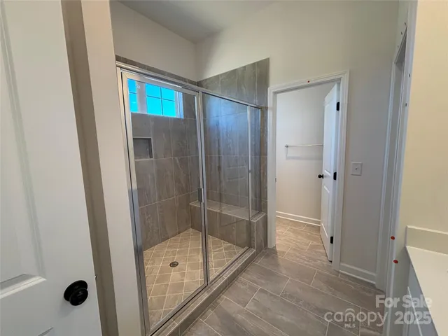 a bathroom with a shower and a glass door