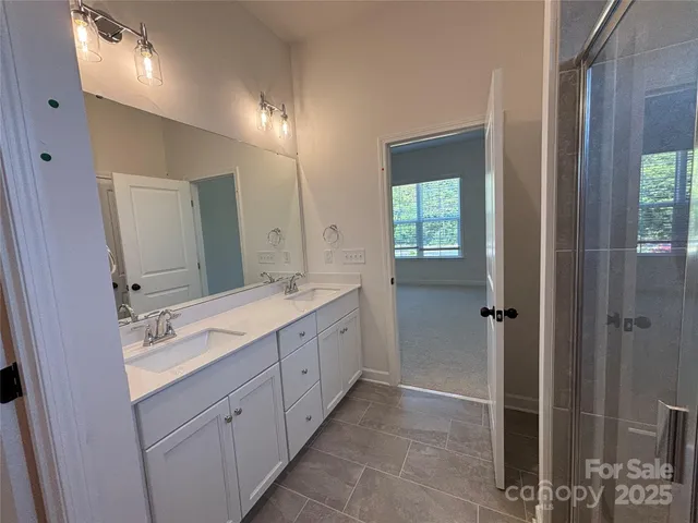 a spacious bathroom with double vanity and a mirror