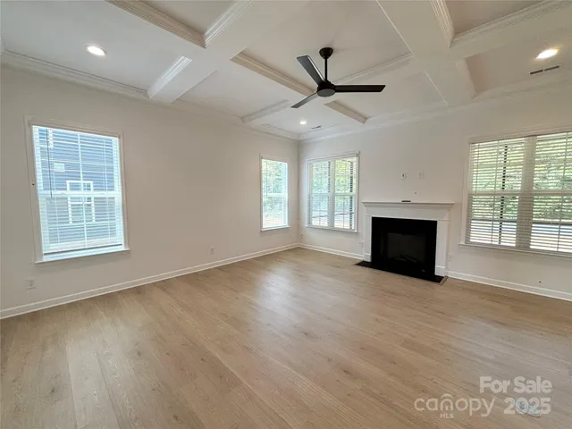 a view of empty room with wooden floor and fireplace