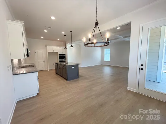 a kitchen with stainless steel appliances a refrigerator and wooden floor