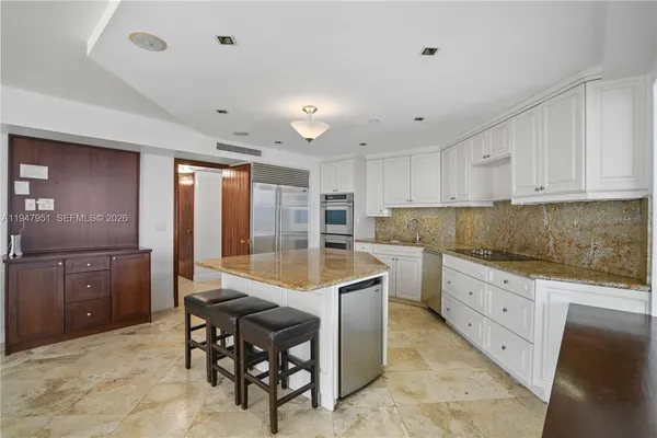 a kitchen with center island table and chairs
