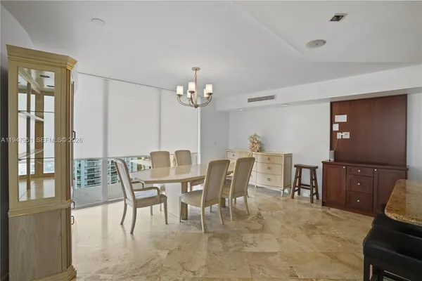 a kitchen with a table chairs refrigerator and cabinets