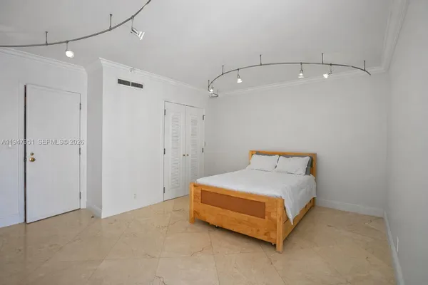 a large bedroom with a bed and a large window