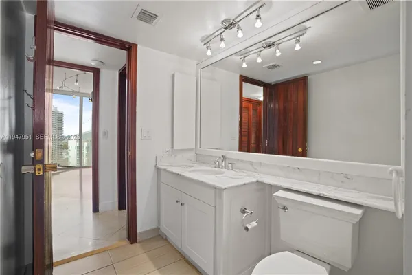 a bathroom with a granite countertop sink a toilet and shower