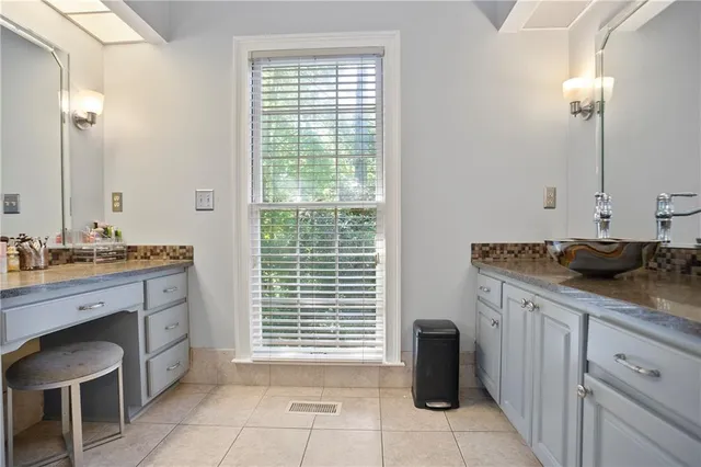 a spacious bathroom with a granite countertop sink and a mirror