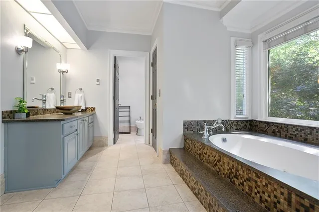 a spacious bathroom with a tub sink and mirror
