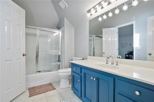 a bathroom with a double vanity sink toilet mirror and shower