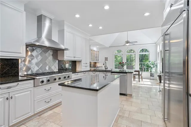 a kitchen with stainless steel appliances granite countertop a stove a sink and a refrigerator