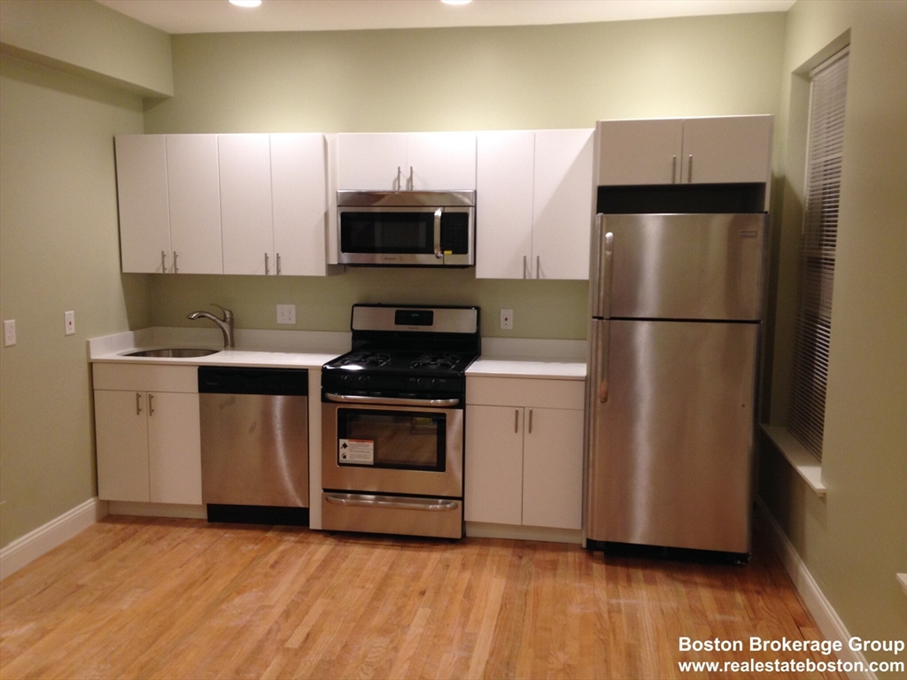 a kitchen with a sink a microwave a refrigerator and cabinets