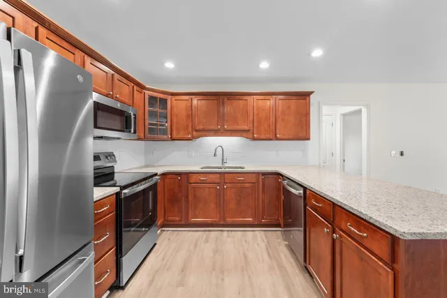 a kitchen with stainless steel appliances granite countertop a stove a sink and a refrigerator