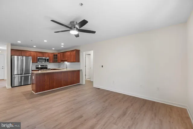 a kitchen with stainless steel appliances granite countertop a refrigerator a sink a stove a microwave and island