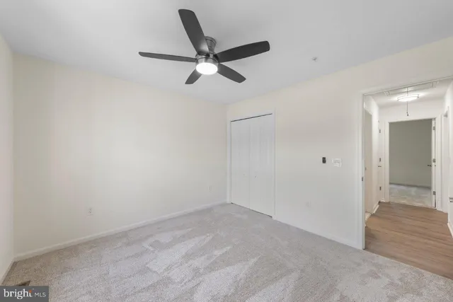 a view of a livingroom with a ceiling fan and wooden floor