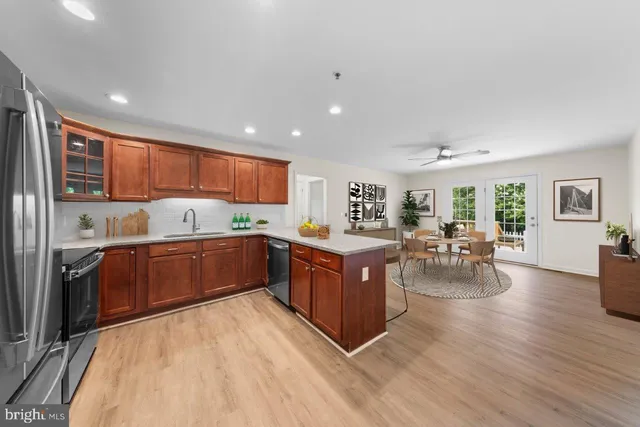 a kitchen with stainless steel appliances kitchen island granite countertop a stove refrigerator and cabinets