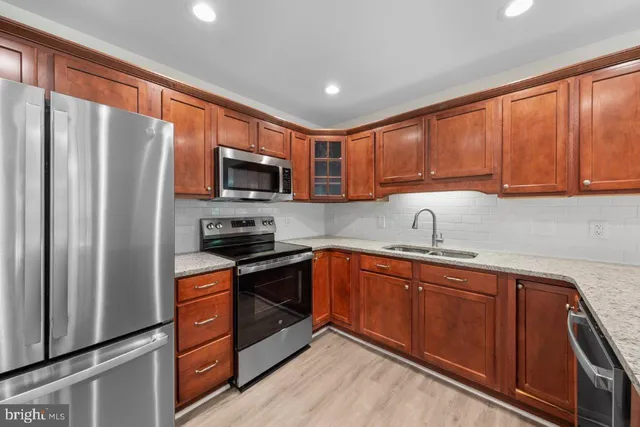 a kitchen with stainless steel appliances granite countertop a refrigerator stove top oven a sink and dishwasher