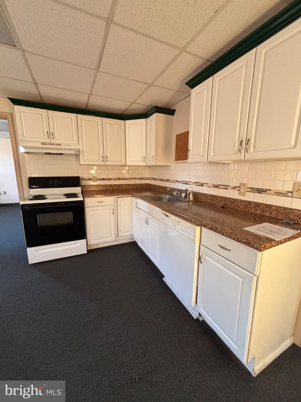 a kitchen with stainless steel appliances granite countertop a stove a sink and white cabinets