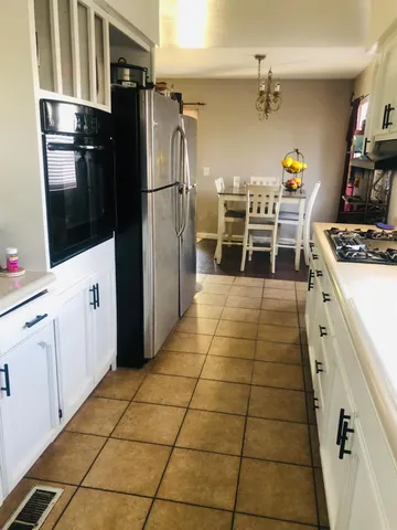 a kitchen with granite countertop a refrigerator and a stove top oven