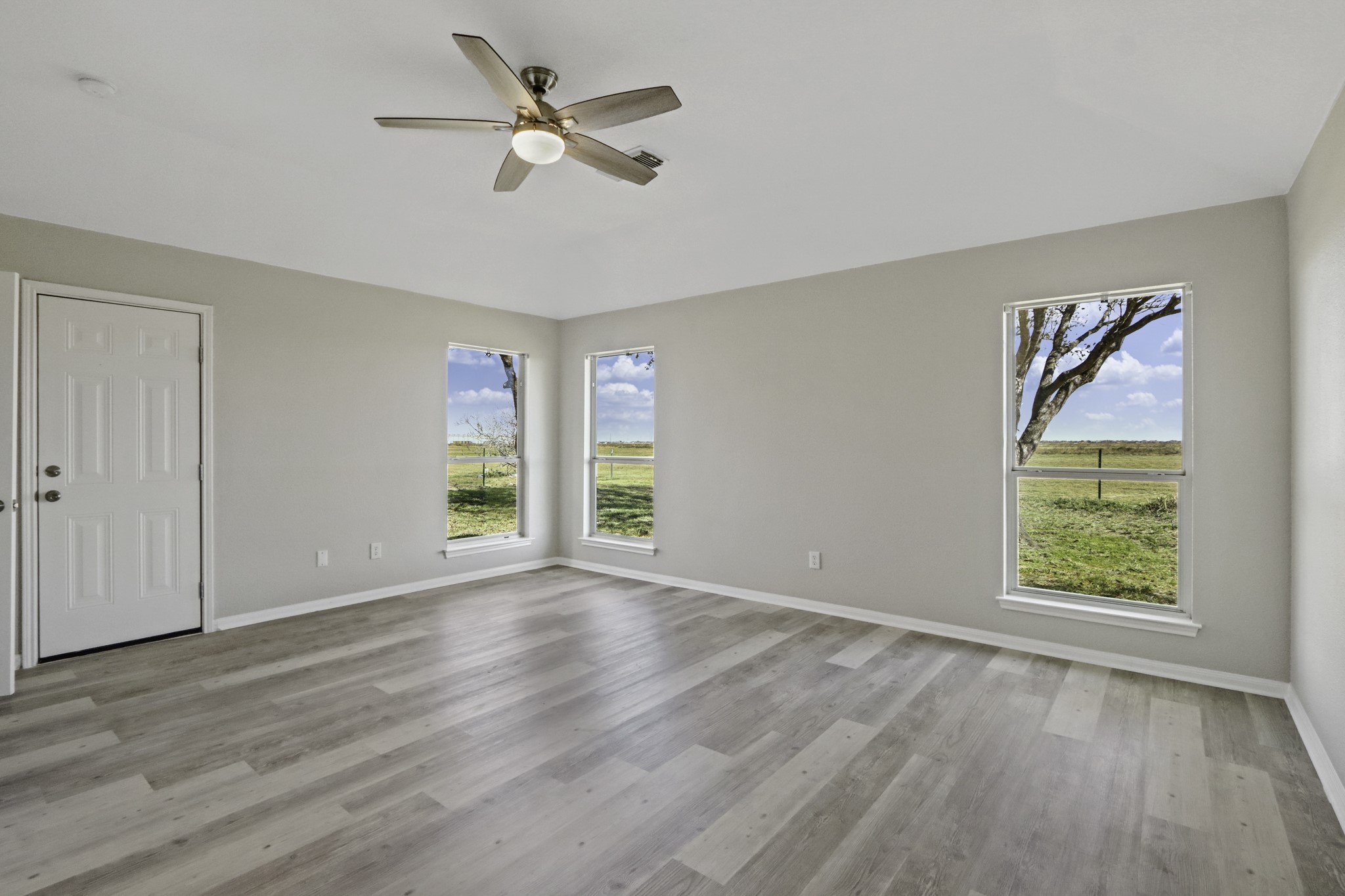 2445 Woods Road Brookshire, TX 77423 - Photo 13 of 29 a view of an empty room with a window and wooden floor