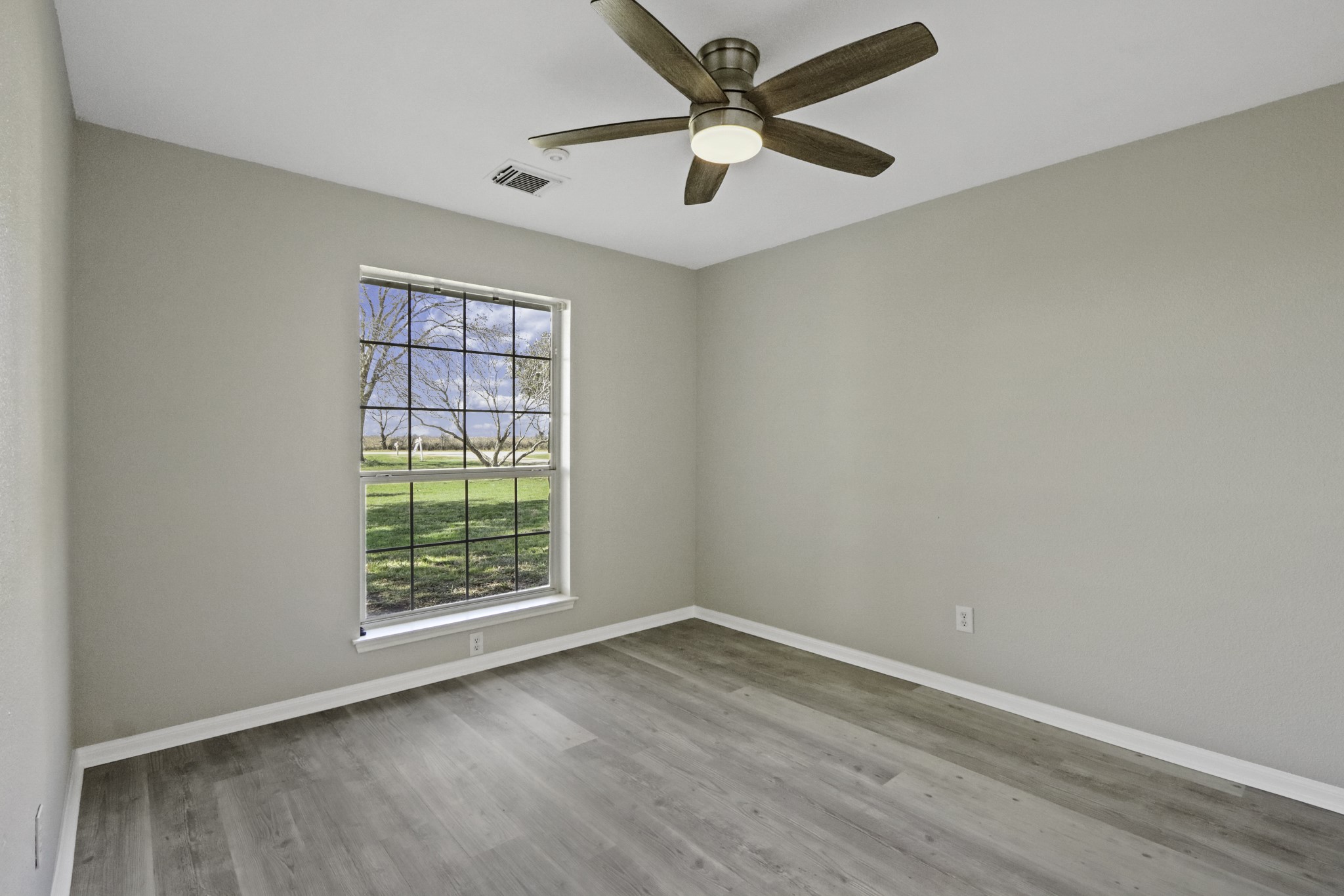 2445 Woods Road Brookshire, TX 77423 - Photo 16 of 29 an empty room with wooden floor and windows