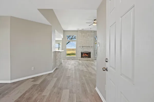 a view of empty room with a fireplace and wooden floor