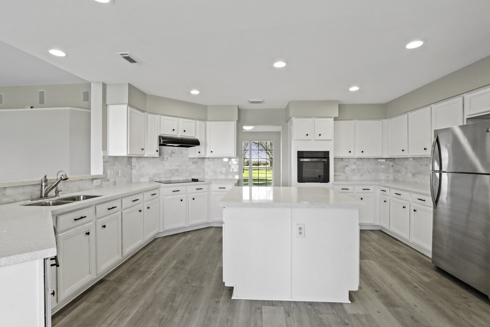 2445 Woods Road Brookshire, TX 77423 - Photo 8 of 29 a large kitchen with stainless steel appliances granite countertop a stove a sink a refrigerator and white cabinets with wooden floor