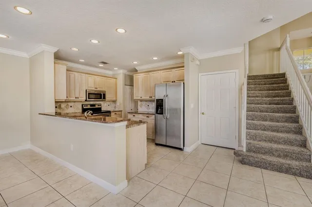 a view of kitchen with refrigerator and cabinets