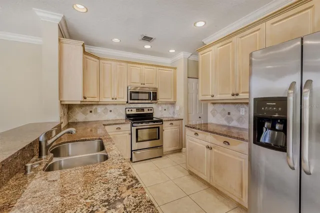 a kitchen with white cabinets and stainless steel appliances