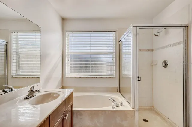 a bathroom with a tub sink and mirror