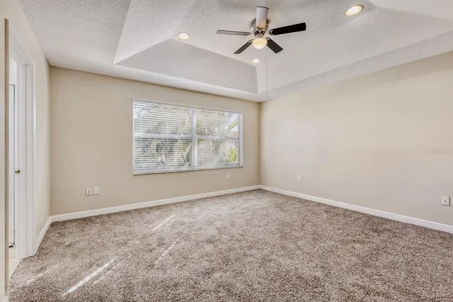 an empty room with windows and fan