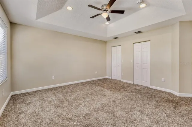 an empty room with a ceiling fan and window
