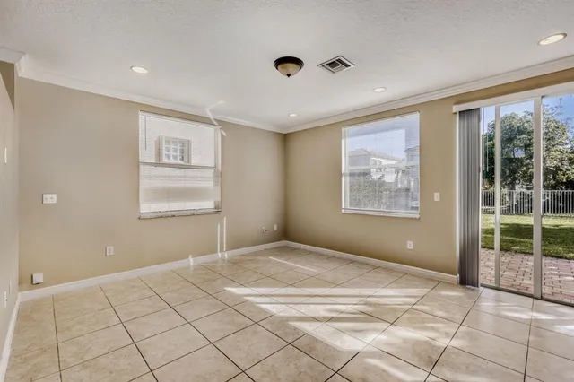 a view of an empty room with window and cabinet