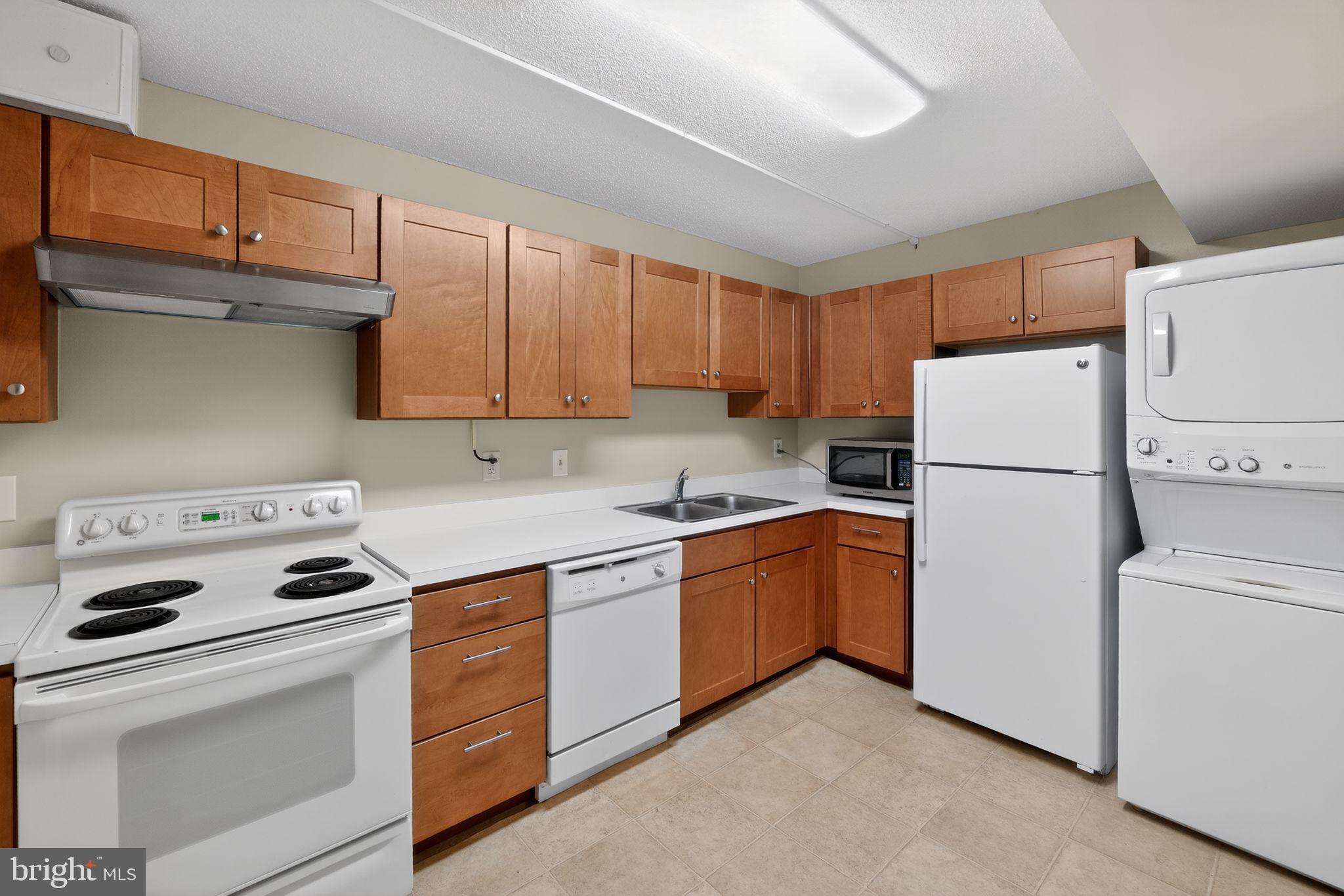 15107 Interlachen Drive, Unit 21022 Silver Spring, MD 20906 - Photo 12 of 33 a kitchen with appliances a sink and a refrigerator