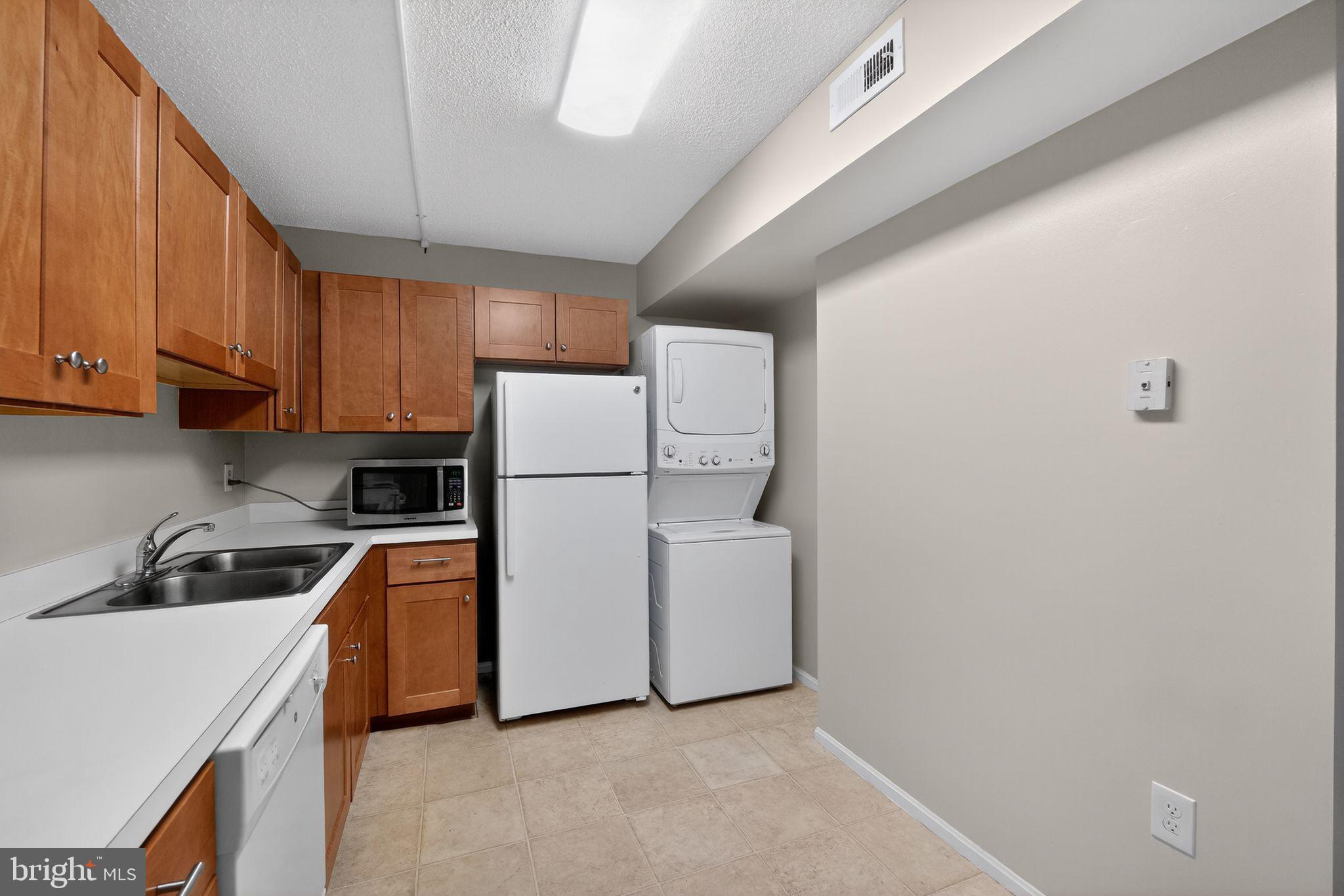 15107 Interlachen Drive, Unit 21022 Silver Spring, MD 20906 - Photo 14 of 33 a kitchen with cabinets a sink and white stainless steel appliances