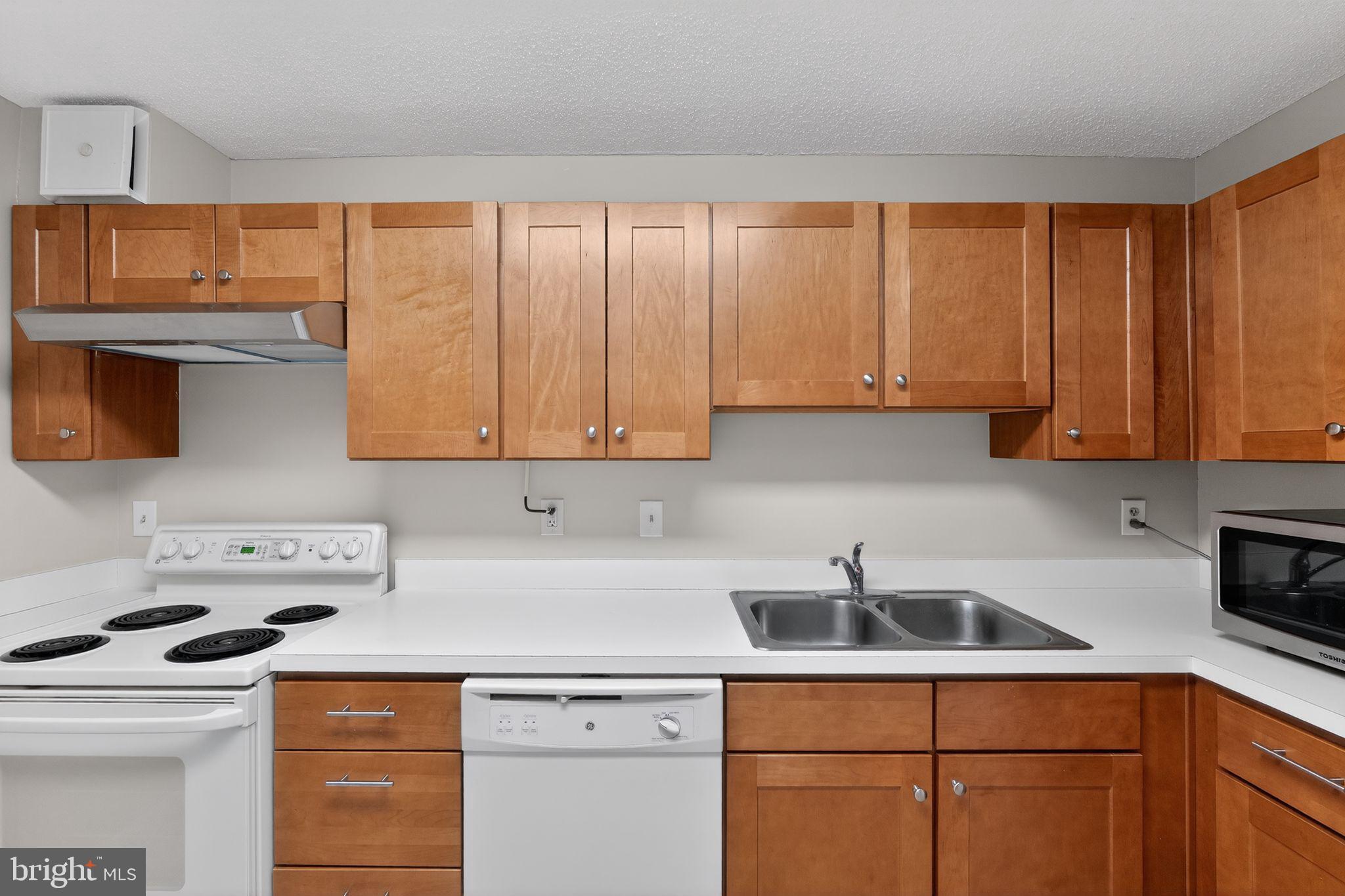 15107 Interlachen Drive, Unit 21022 Silver Spring, MD 20906 - Photo 15 of 33 a kitchen with stainless steel appliances granite countertop a sink a stove and cabinets