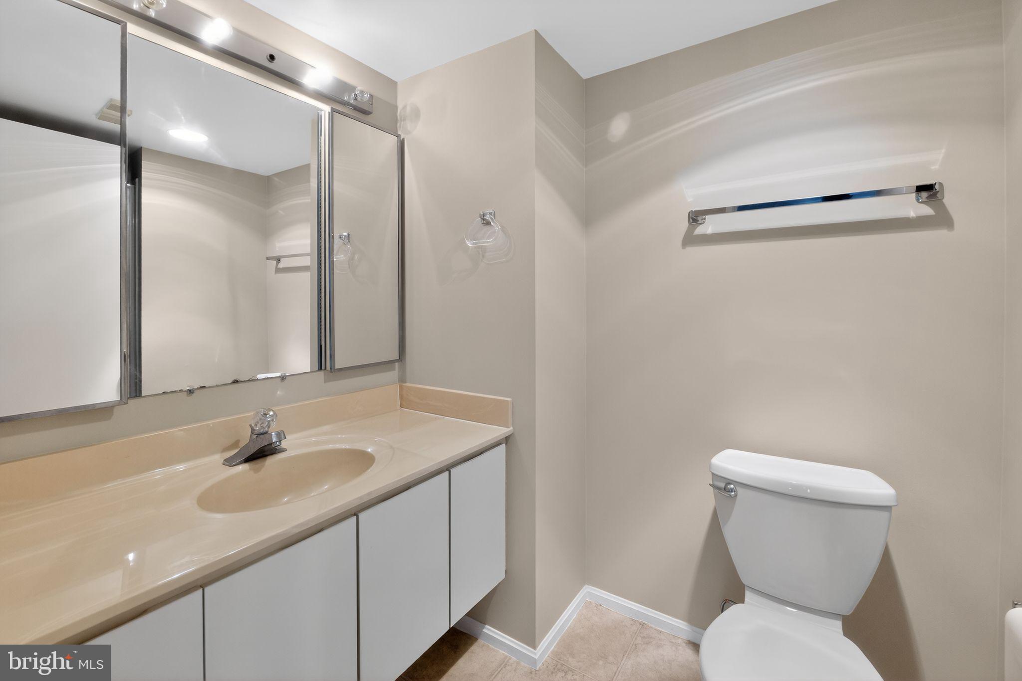 15107 Interlachen Drive, Unit 21022 Silver Spring, MD 20906 - Photo 25 of 33 a bathroom with a granite countertop sink toilet and shower