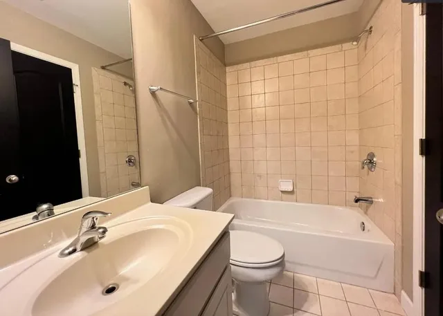 a bathroom with a bathtub shower sink and a toilet