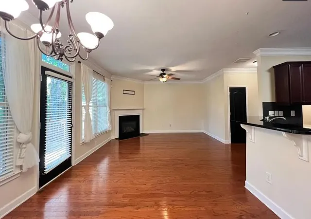 a view of a livingroom with a fireplace a chandelier and wooden floor