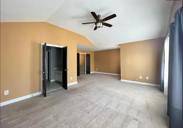 a view of a livingroom with a ceiling fan & entryway