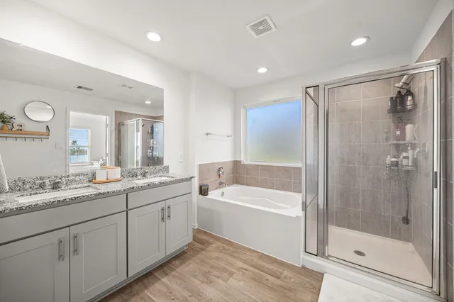 a bathroom with a tub a sink shower and mirror