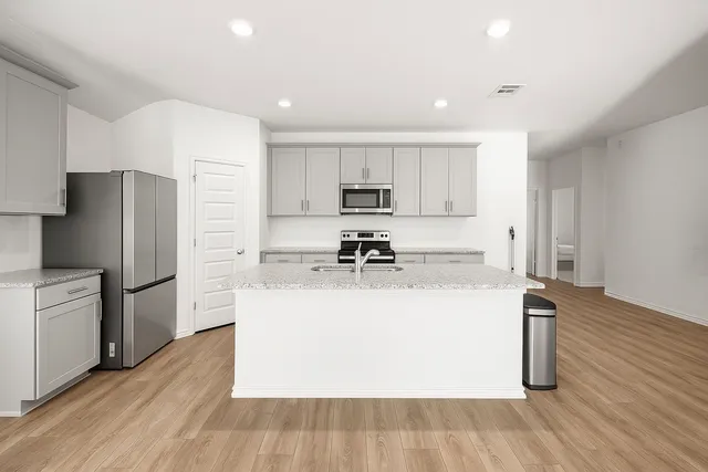 a kitchen with a refrigerator a sink and a stove top oven