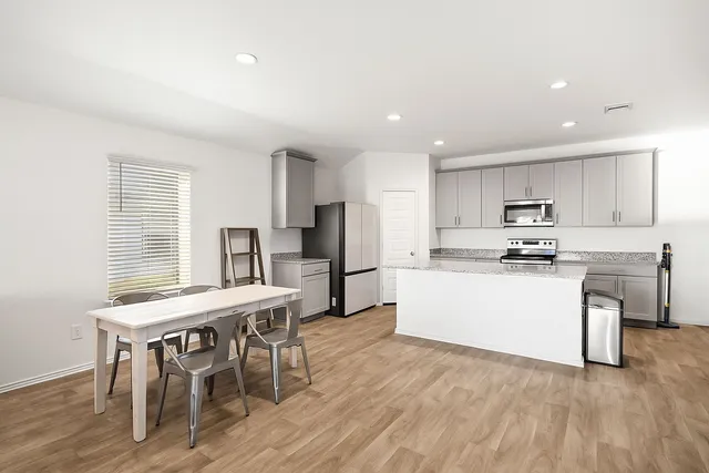 a kitchen with white cabinets and stainless steel appliances