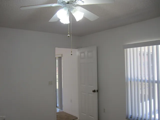 a view of a hallway with a chandelier fan and a livingroom