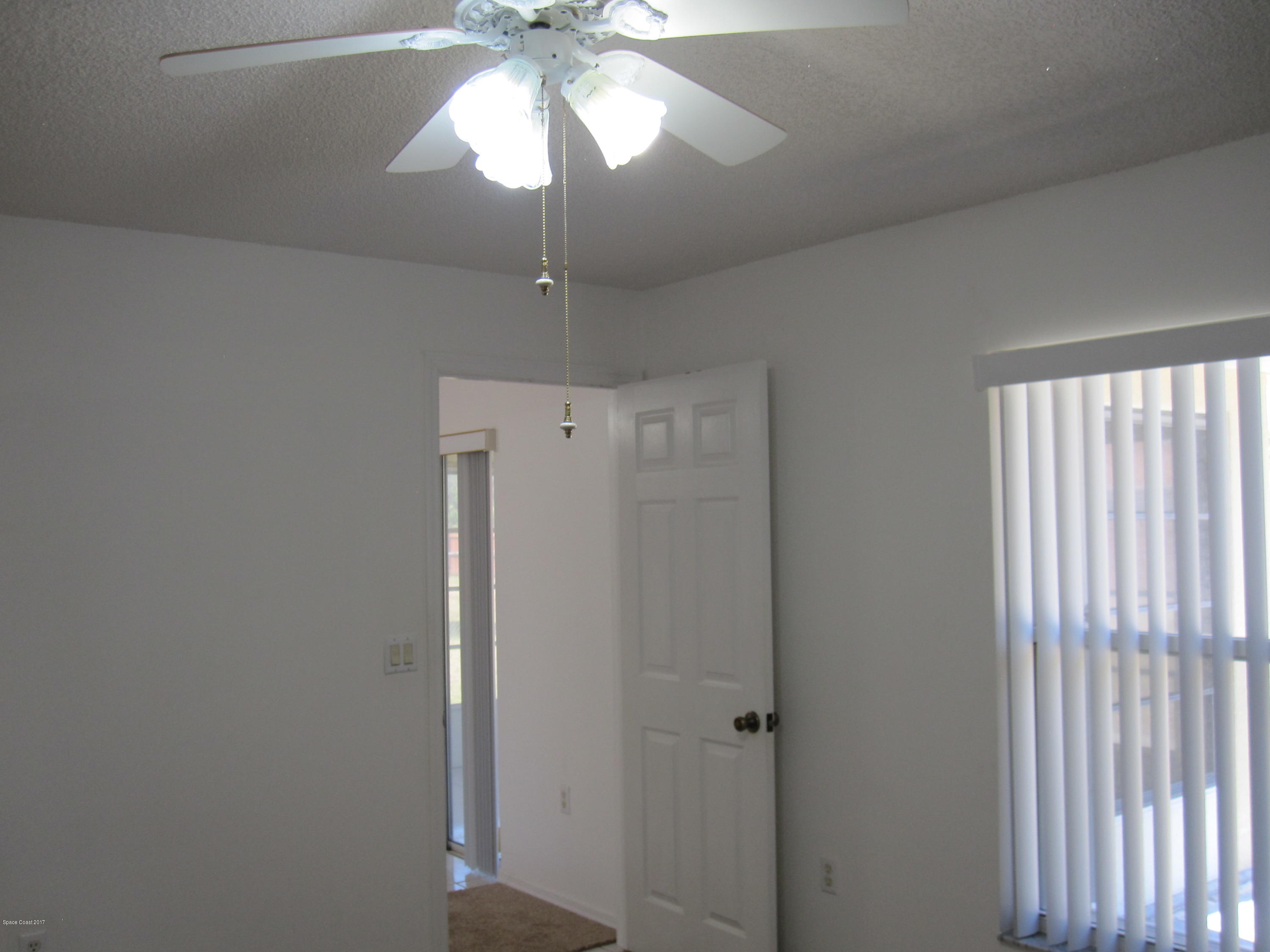 171 Americana Boulevard Northeast Palm Bay, FL 32907 - Photo 14 of 17 a view of a hallway with a chandelier fan and a livingroom