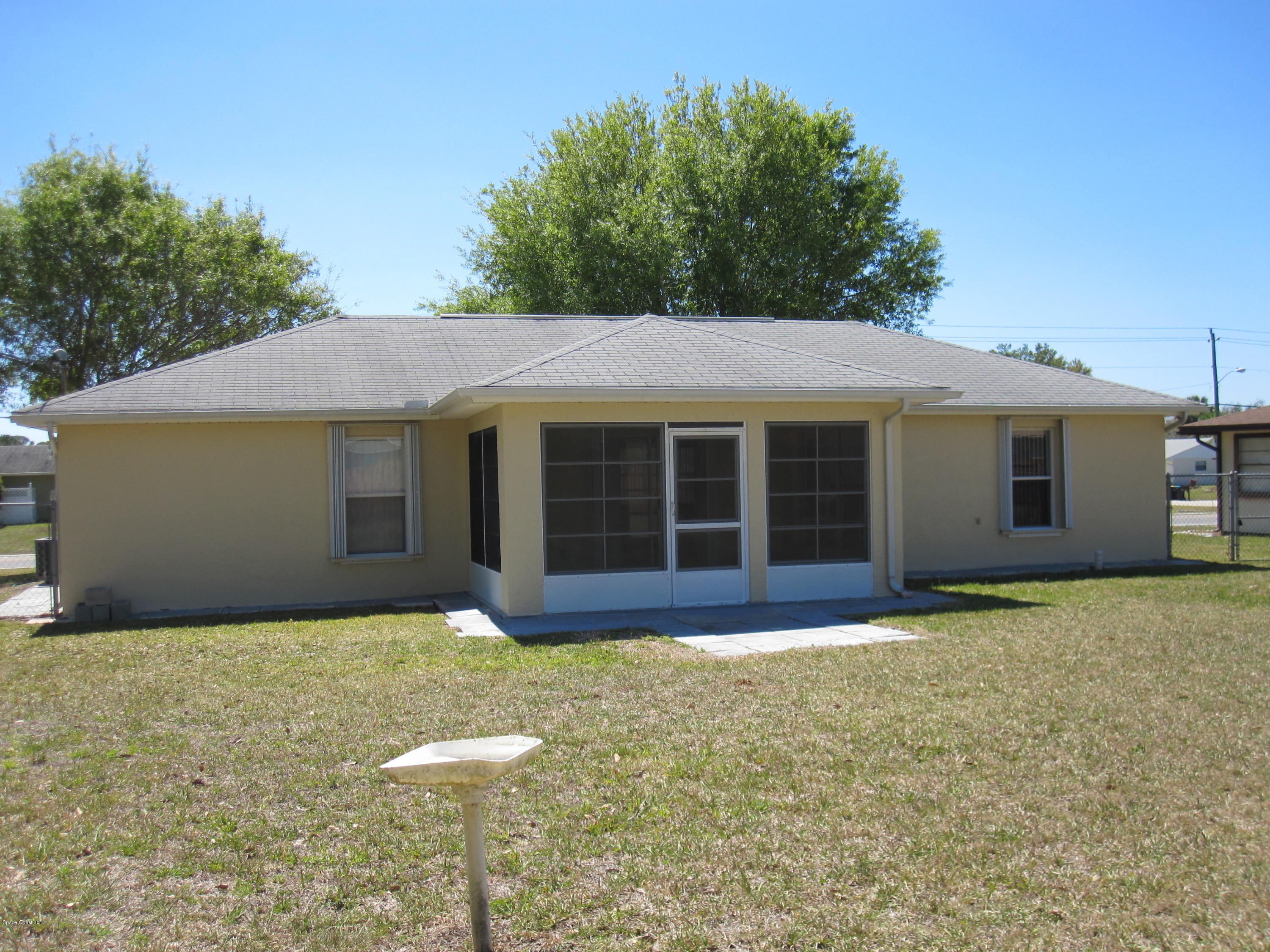171 Americana Boulevard Northeast Palm Bay, FL 32907 - Photo 16 of 17 a front view of a house with a garden and yard