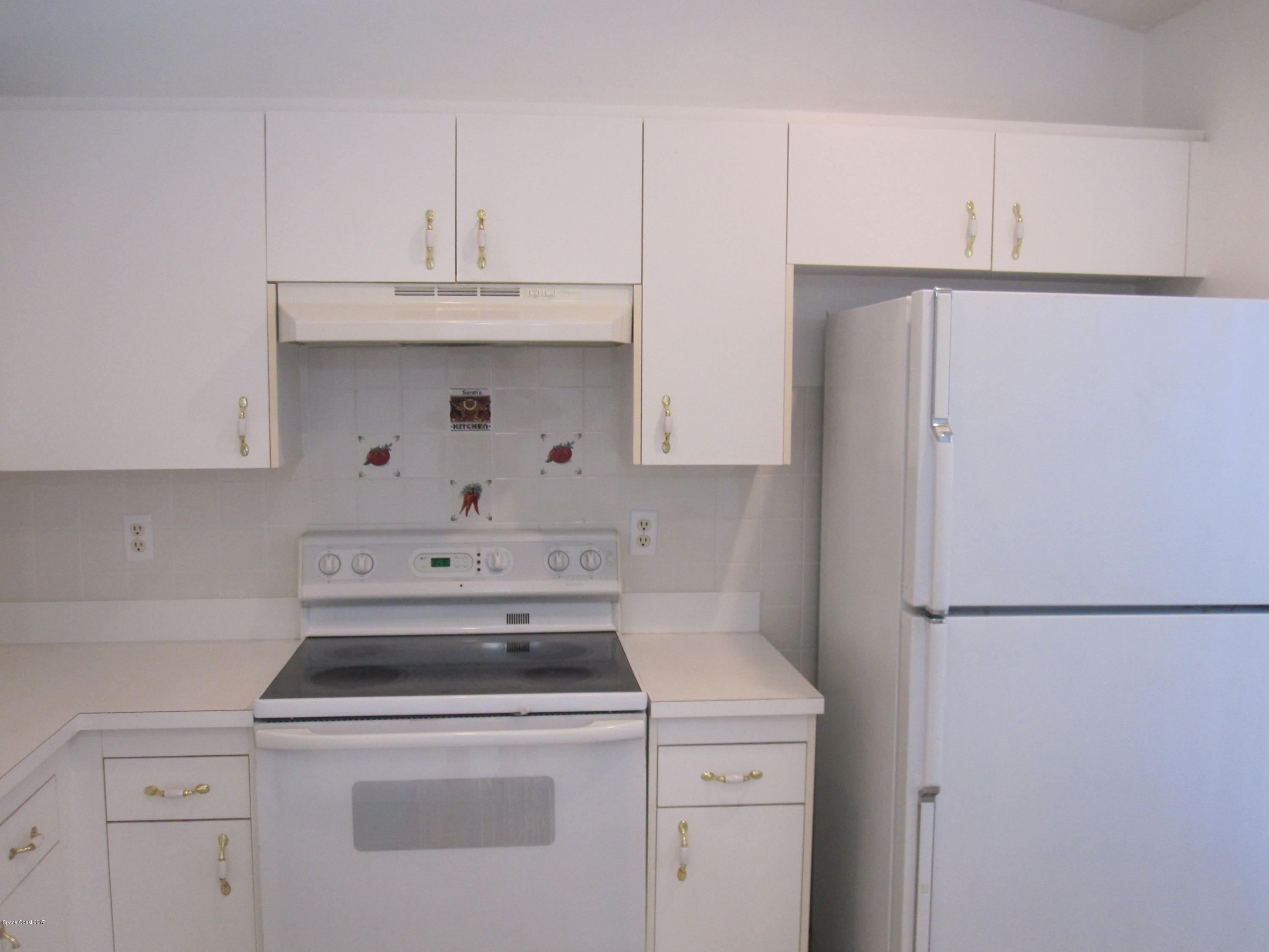 171 Americana Boulevard Northeast Palm Bay, FL 32907 - Photo 8 of 17 a kitchen with a sink a stove and refrigerator
