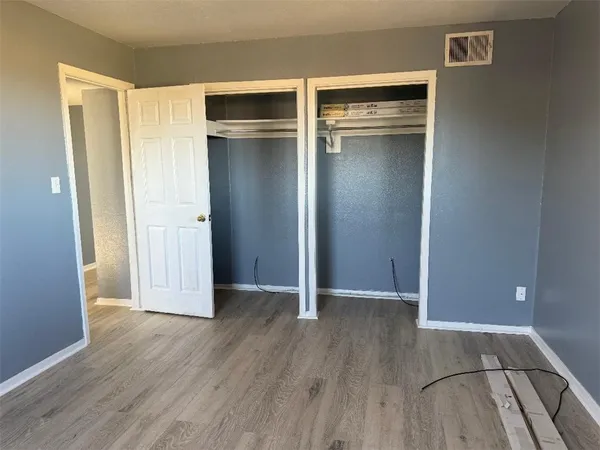 an empty room with wooden floor and closet