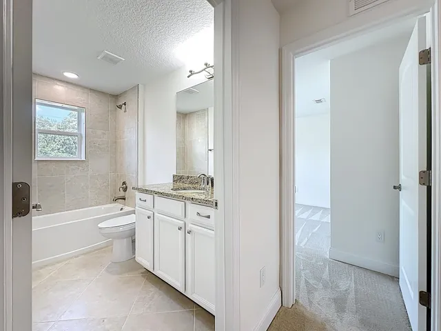 a bathroom with a tub shower and toilet