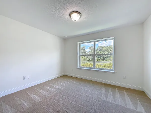 a bedroom with a large bed and a chandelier fan