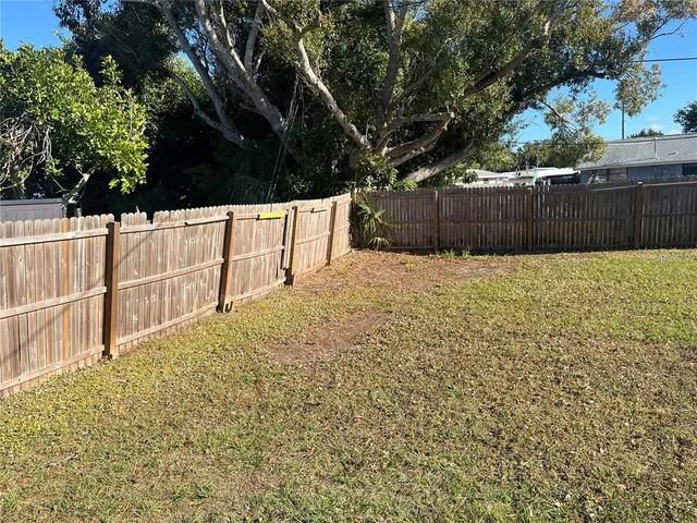 a view of backyard with wooden fence