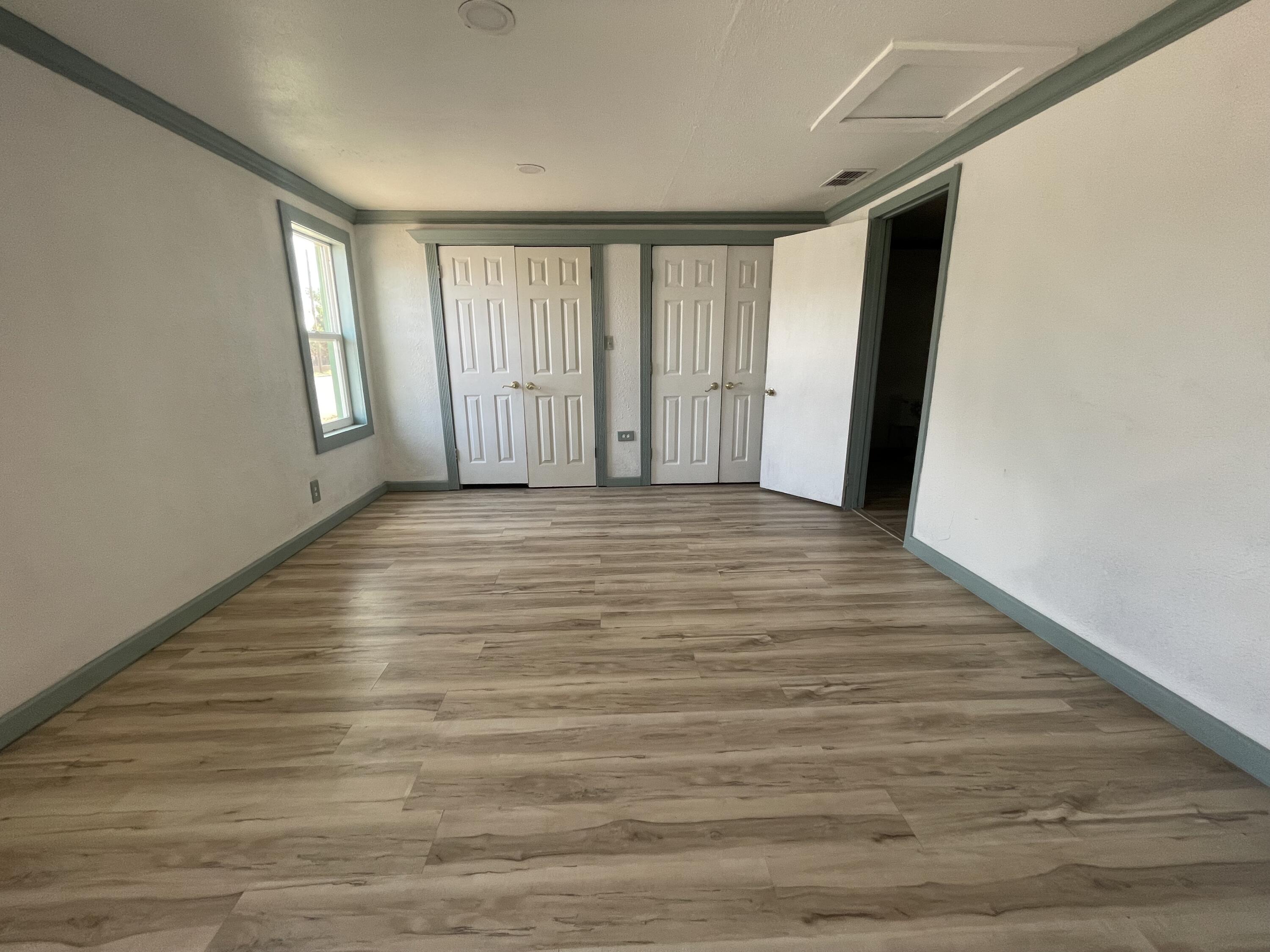 325 South 13th Street Slaton, TX 79364 - Photo 11 of 35 a view of an empty room with window and wooden floor